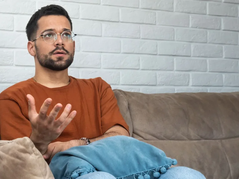 Mann sitz auf Couch und erzählt